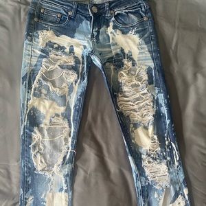 Size 1-3 ripped, dark blue, light blue, & white paint splatter skinny jeans.